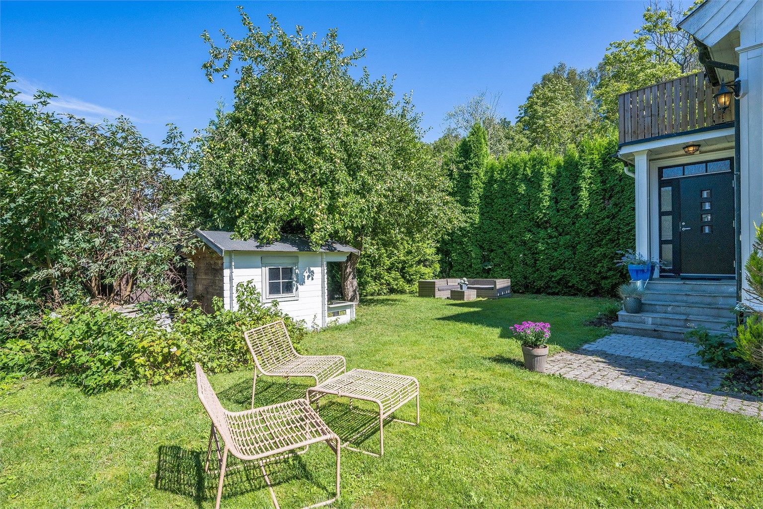 Boligen har en solrik og sjarmerende hage som er pent opparbeidet med plen, epletre og diverse beplantning. Foto: Kristian Bollæren v/Fotofinish