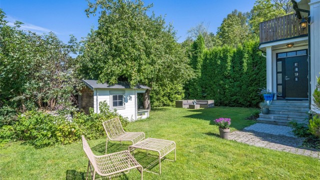 Boligen har en solrik og sjarmerende hage som er pent opparbeidet med plen, epletre og diverse beplantning. Foto: Kristian Bollæren v/Fotofinish