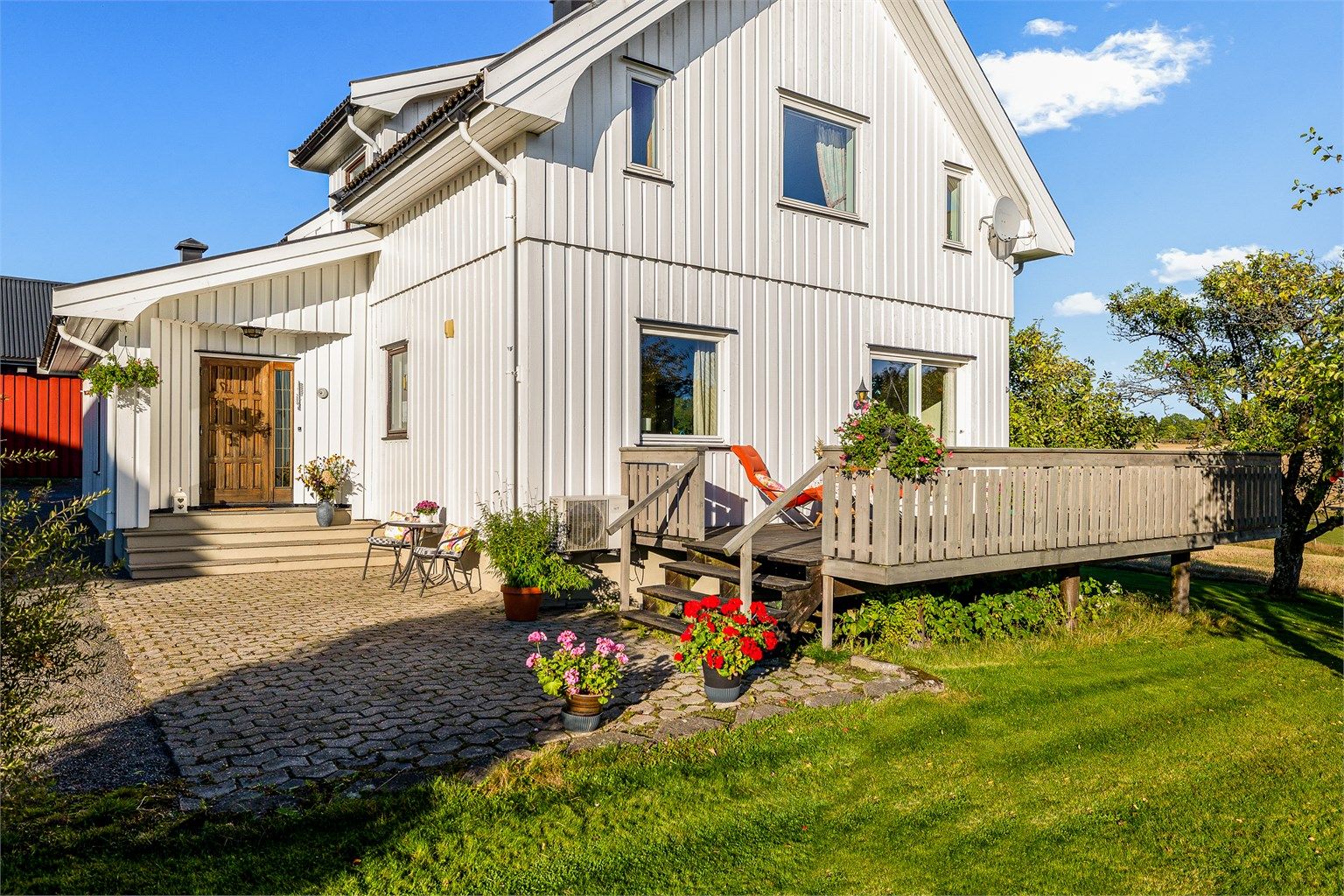 Uteplassen foran huset er steinbelagt og har trappetilkomst opp til verandaen.