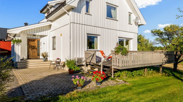 Uteplassen foran huset er steinbelagt og har trappetilkomst opp til verandaen.