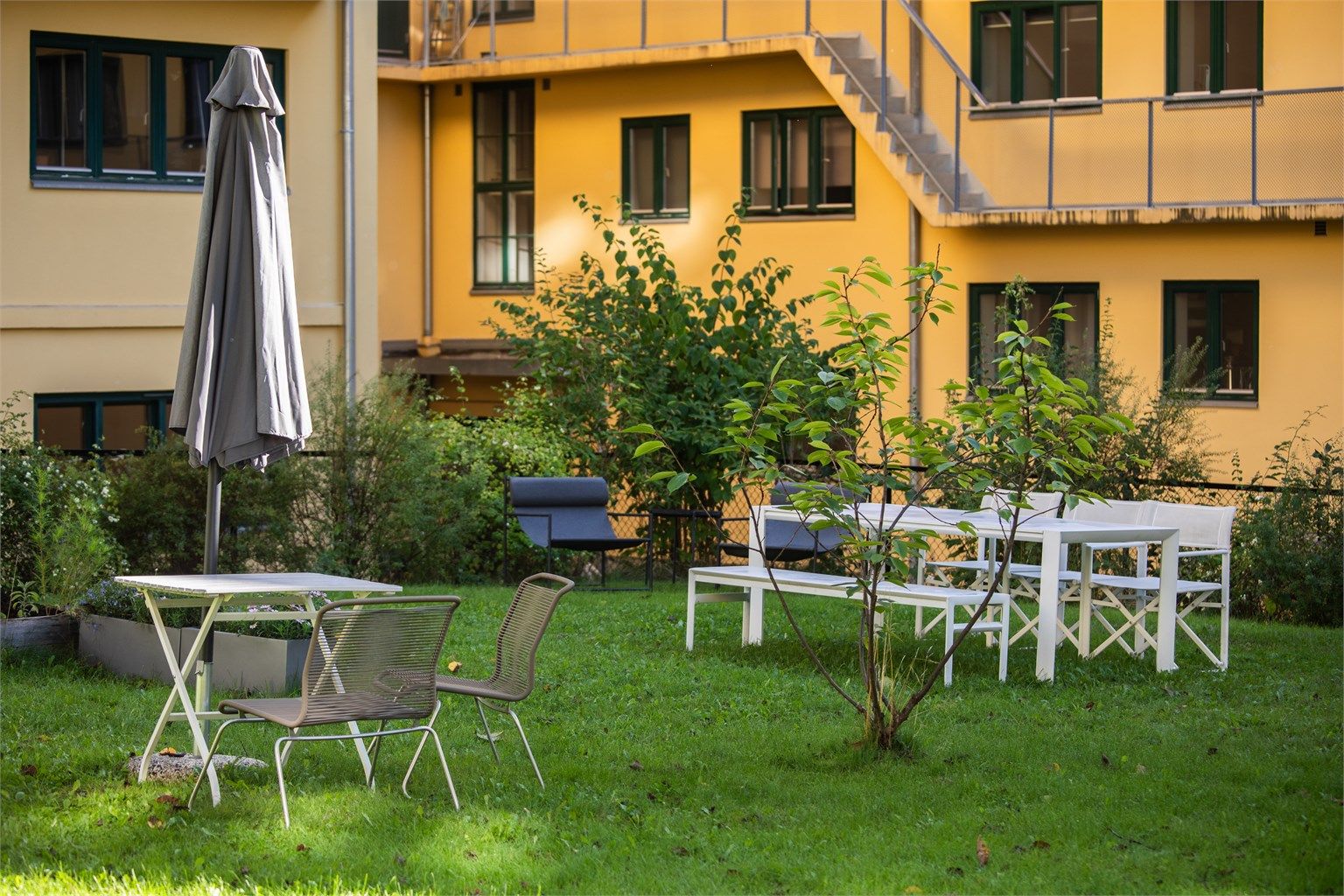 Boligen er omgitt av en frodig bakgård som oppleves som en liten oase midt i byen. 