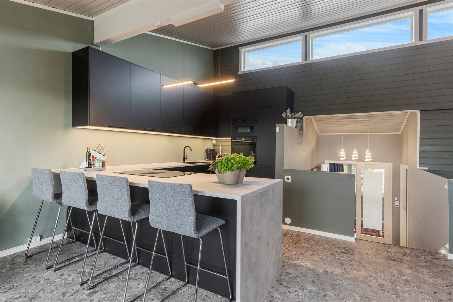 Kjøkkenet ligger naturlig tilbaketrukket fra stuen og har integrert stekeovn, platetopp, oppvaskmaskin, mikrobølgeovn og kjøleskap med fryser.