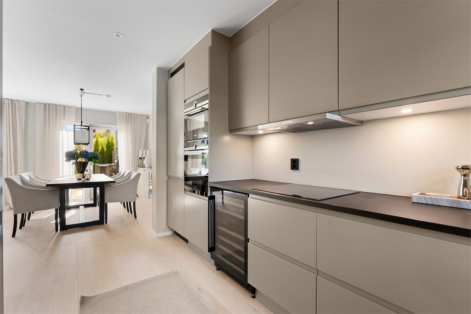 Kjøkkenet har en åpen løsning mot spisestuen, med laminatbenkeplate og downlights.