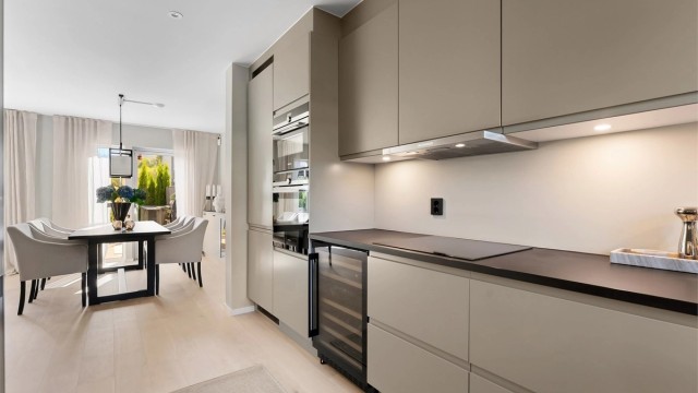 Kjøkkenet har en åpen løsning mot spisestuen, med laminatbenkeplate og downlights.