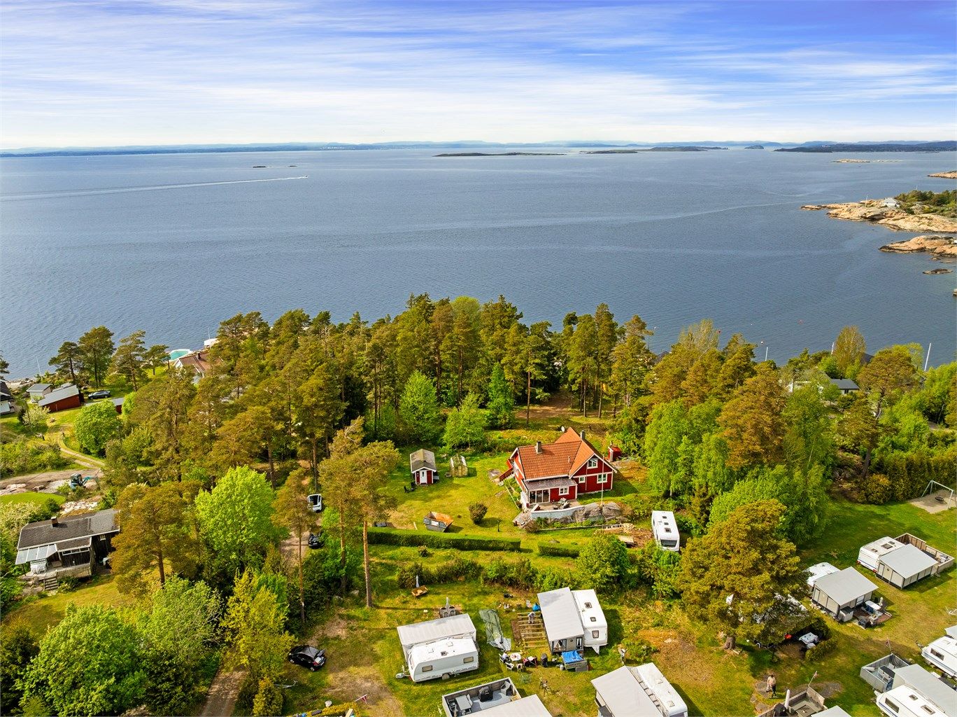 Eiendommen ligger som en stor lysning i skogen, godt avskjermet fra både campingområdet ovenfor og øvrige fritidsboliger omkring.