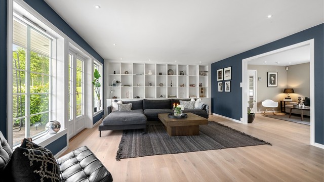 Stuen har flere soner, med en plassbygget bokhylle og god plass til en stor sofagruppe.