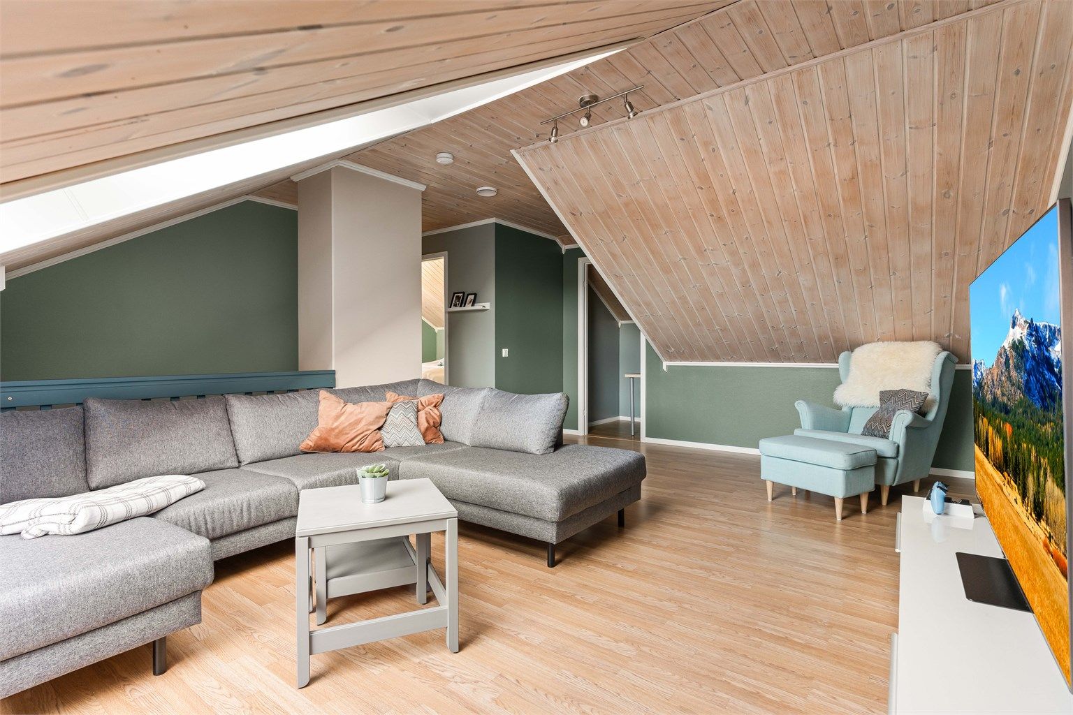 Loftstuen har parkett på gulvet og trepanel i himlingen, som skaper en lun atmosfære.