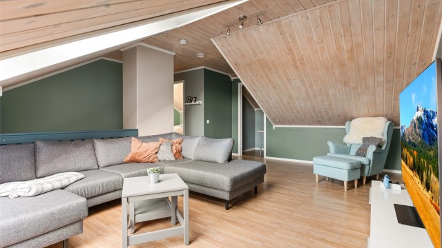 Loftstuen har parkett på gulvet og trepanel i himlingen, som skaper en lun atmosfære.