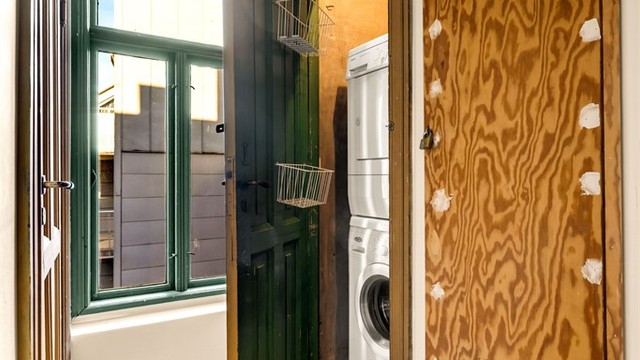 Opplegg og plass for vaskemaskin og tørketrommel befinner seg i eget vaskerom/trappebod en halv etasje opp fra leiligheten, via baktrapp utenfor soverommet.