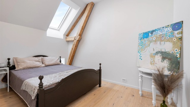 Loftsetasjen byr på sjarmerende soverom med synlige bjelker og lys fra takvinduer