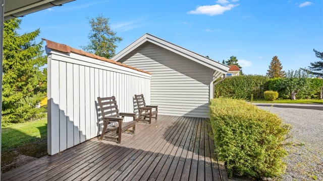 Åpen terrasse med spaltegulv i impregnert treverk og skjermende levegg.