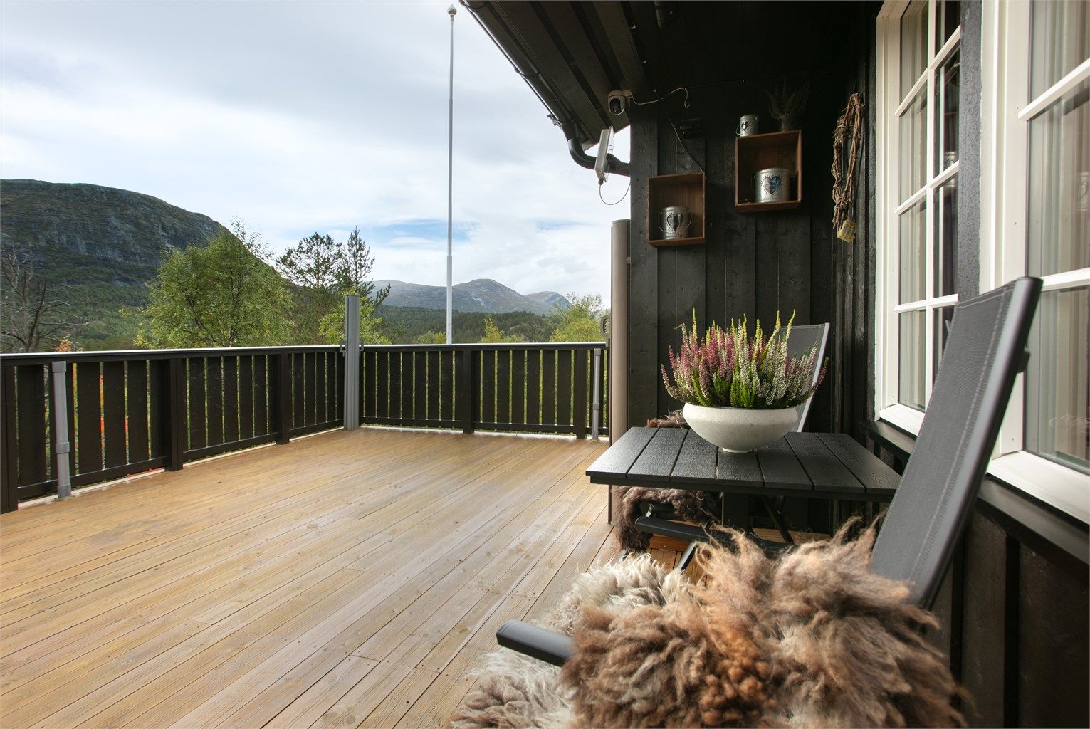 Fra terrassen er det åpent utsyn mot fjellene og omkringliggende skog.