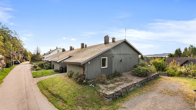 Det er hyggelig grøntareal rundt og foran boligen. Til høyre har nåværende eier parkert sine biler (se pkt. parkering).