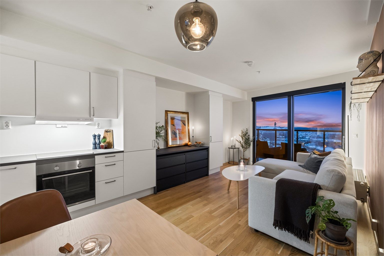 Den åpne løsningen mellom stue og kjøkken skaper en lys og luftig atmosfære.