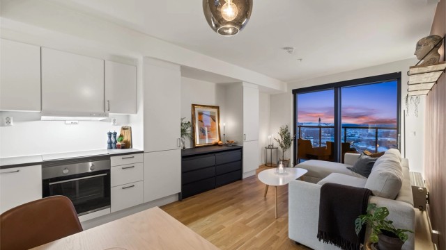 Den åpne løsningen mellom stue og kjøkken skaper en lys og luftig atmosfære.