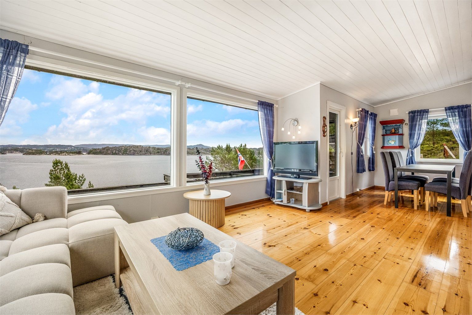 Stuen har plass til både sofagruppe og spisebord, med heltregulv og panel i taket.