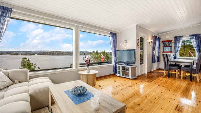 Stuen har plass til både sofagruppe og spisebord, med heltregulv og panel i taket.