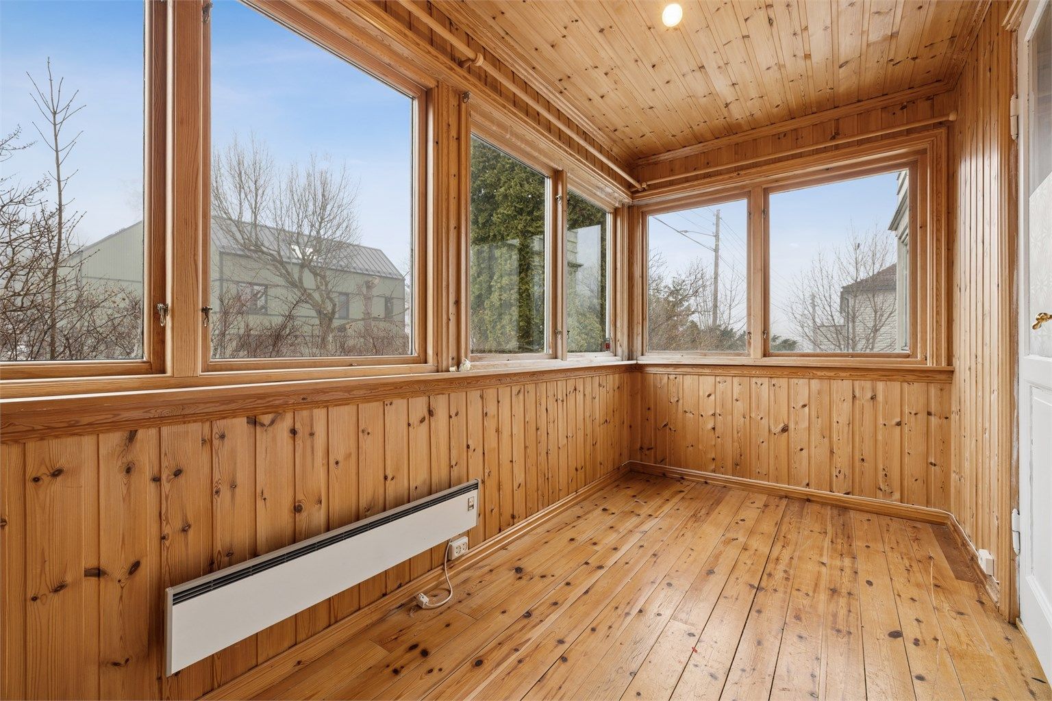 Vinterhagen er kledd med tregulv og trepanel, og fungerer som en forlengelse av stuen.