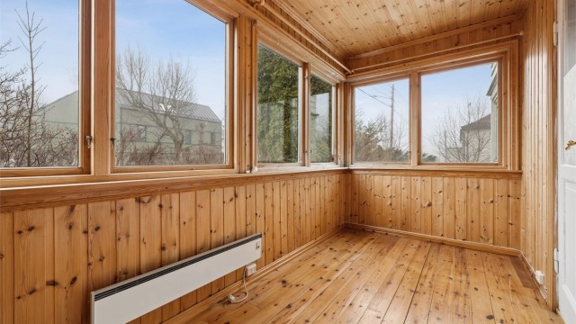 Vinterhagen er kledd med tregulv og trepanel, og fungerer som en forlengelse av stuen.