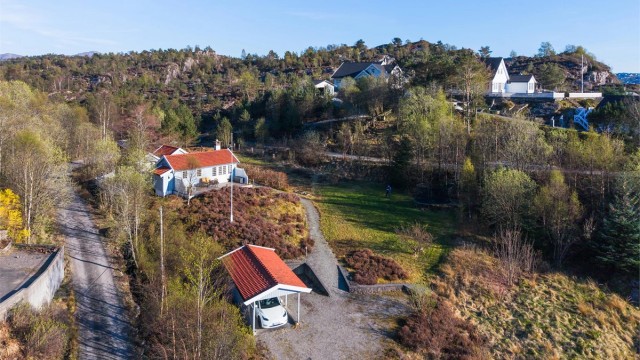 Det er gode parkeringsmuligheter på tomten med både carport, parkeringsplass på grus og parkeringsplass bak anneksene.