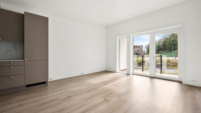 Åpen stue- og kjøkkenløsning med plass til både sofagruppe og spisebord.