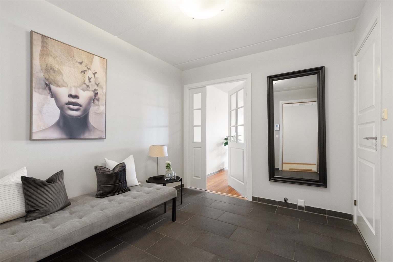 Entréen har praktisk flislagt gulv og er, som resten av leiligheten, svært romslig med plass til en stor sittebenk.