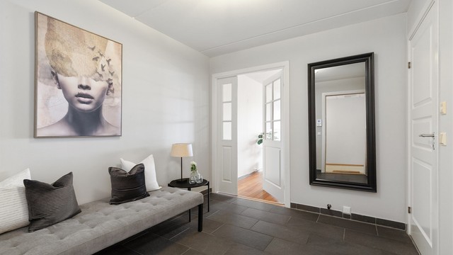 Entréen har praktisk flislagt gulv og er, som resten av leiligheten, svært romslig med plass til en stor sittebenk.