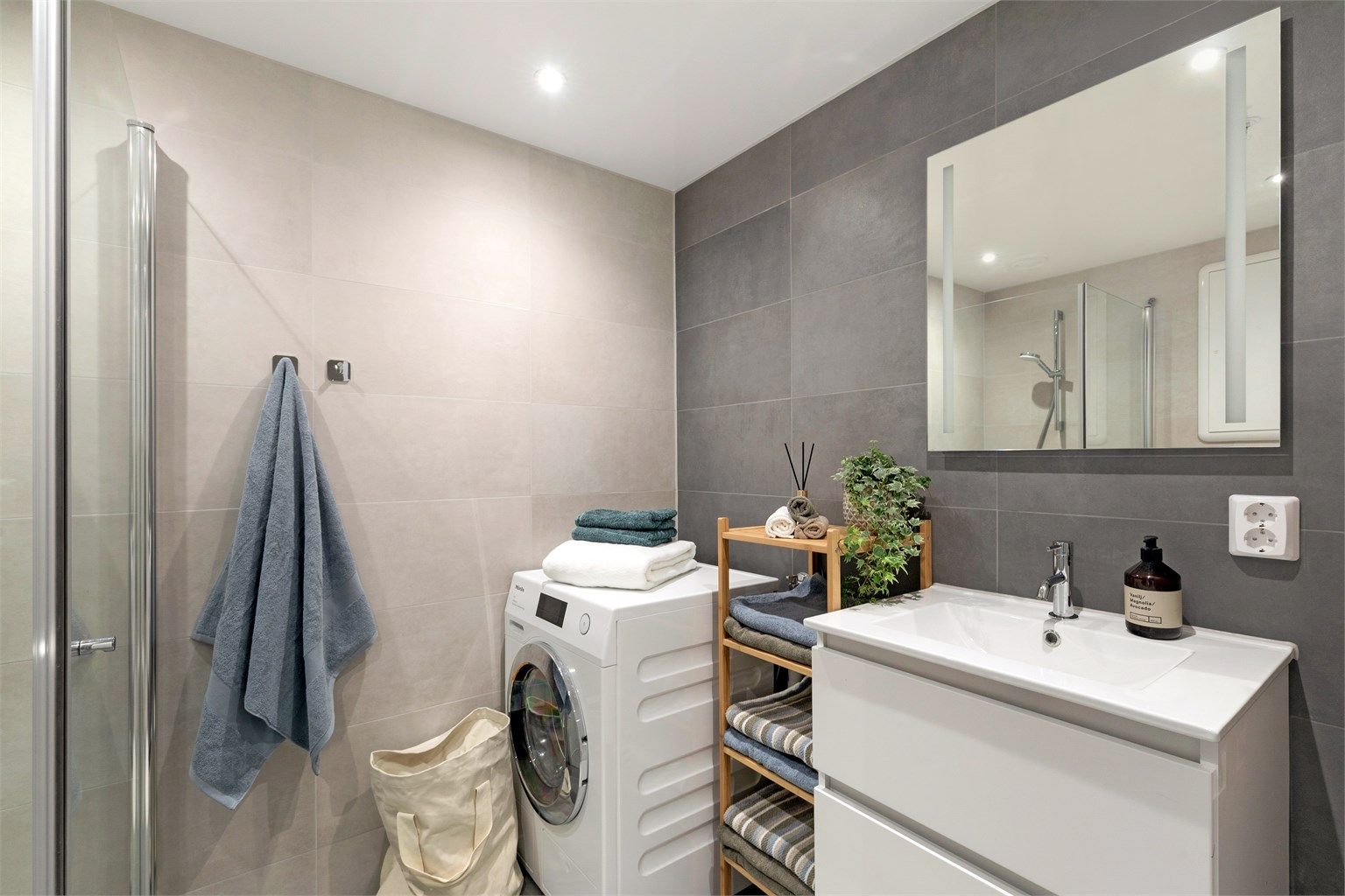 Badet er holdt i tidløse farger. Det er opplegg for vaskemaskin 