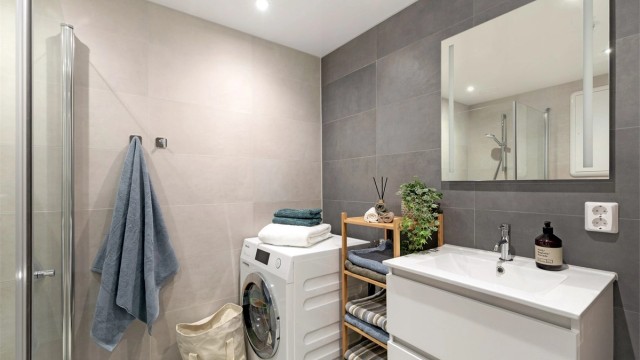 Badet er holdt i tidløse farger. Det er opplegg for vaskemaskin