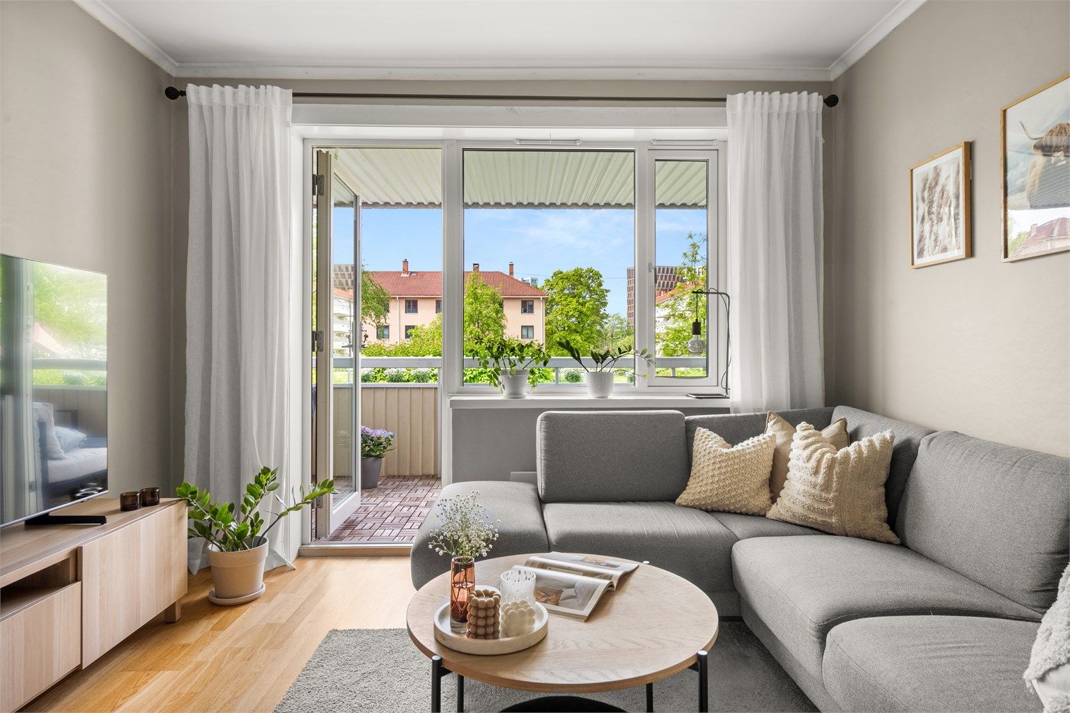 Store vindusflater og balkongdør fra 2018 slipper inn dagslys i stuen.