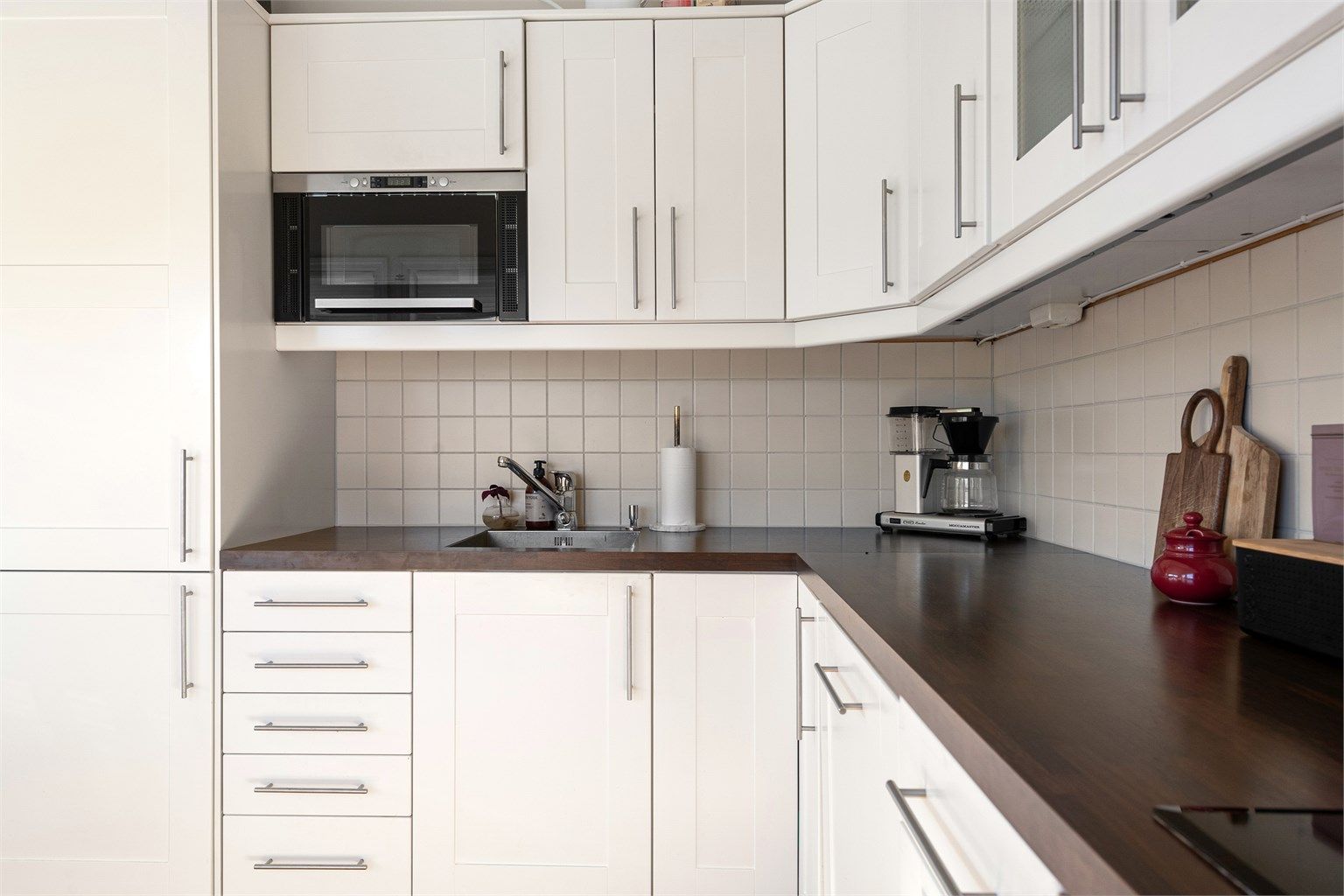Hvit profilert kjøkkeninnredning med laminert benkeplate med gode arbeidsforhold