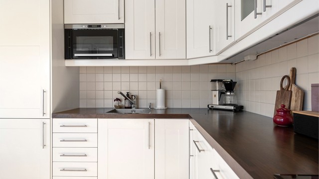Hvit profilert kjøkkeninnredning med laminert benkeplate med gode arbeidsforhold