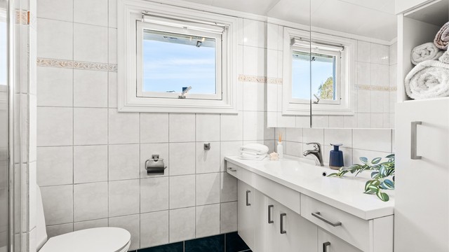 Badet i andre etasje er fra 1996 og har flislagt gulv med gulvvarme, dusjnisje og vegghengt servantinnredning.