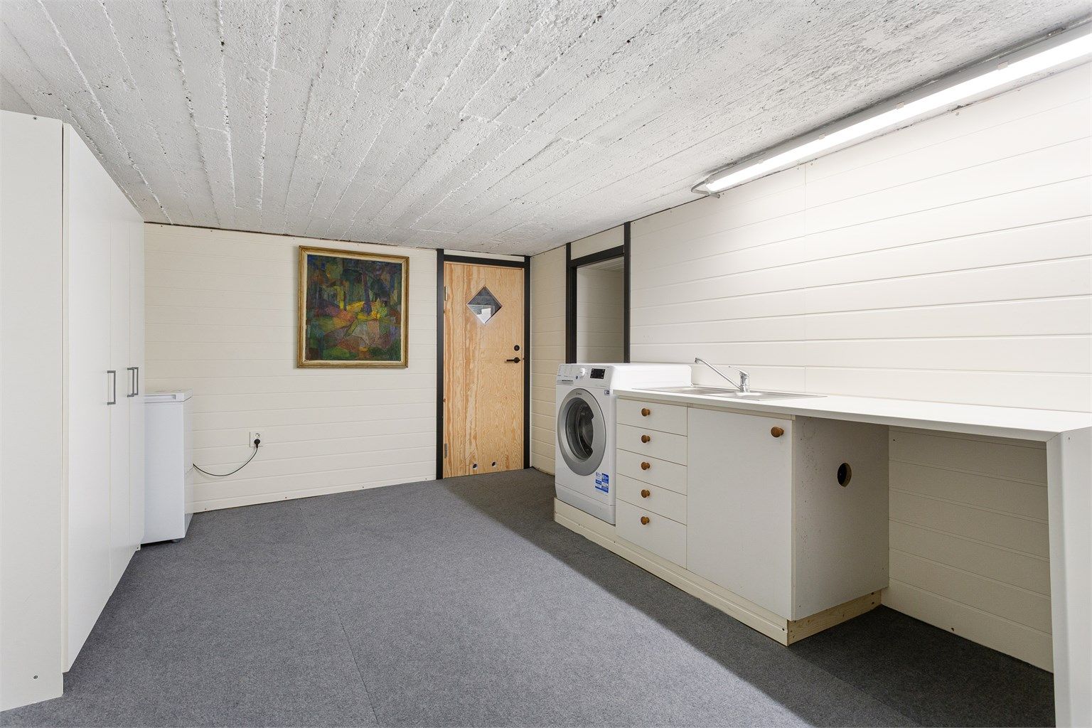 Bod i kjeller med plass til oppbevaring. Opplegg for vaskemaskin plassert i bod. Rommet er ikke bygget som våtrom.