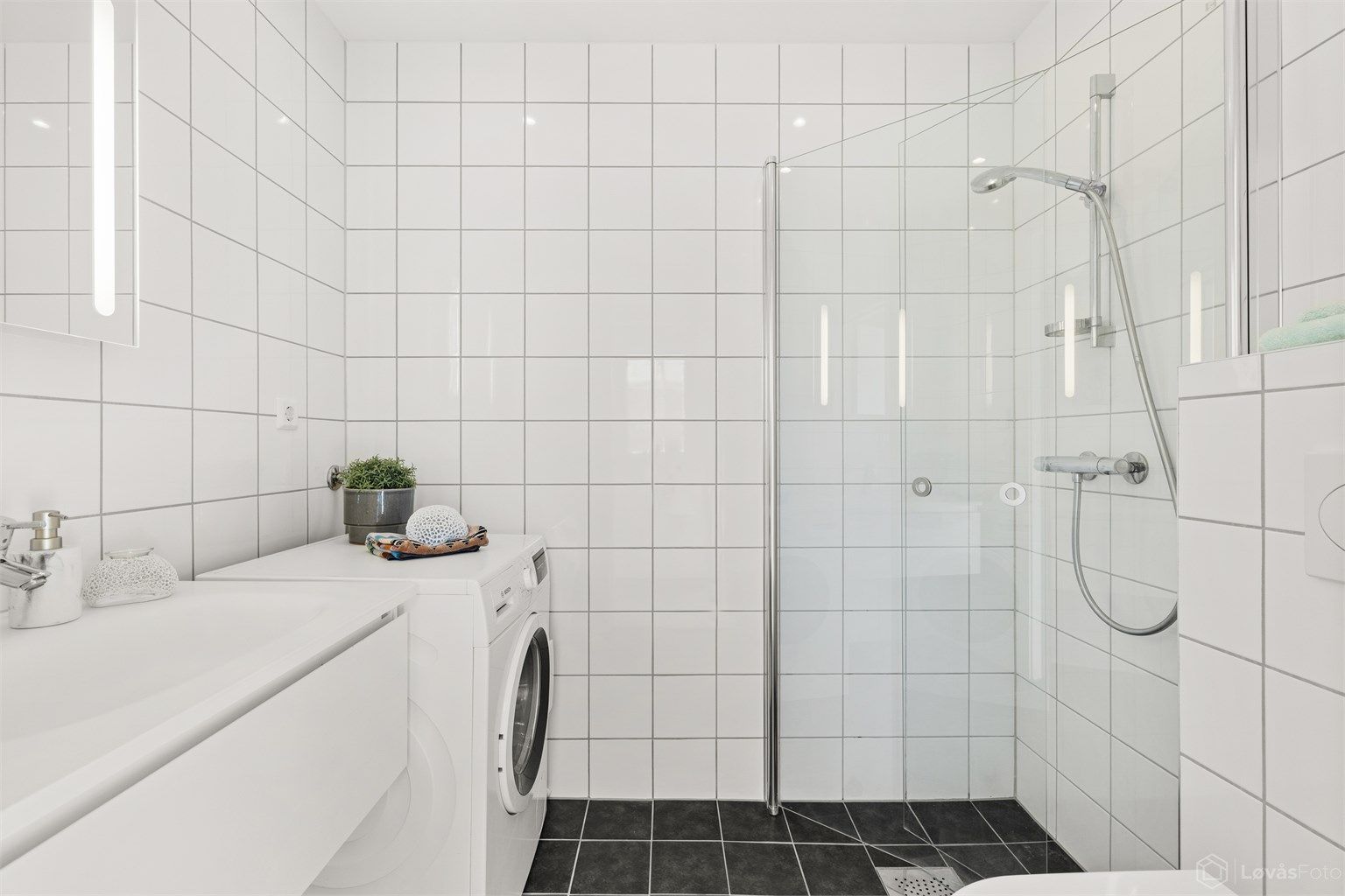 Bad med vannbåren gulvvarme og downlights i himling. Opplegg for vaskemaskin