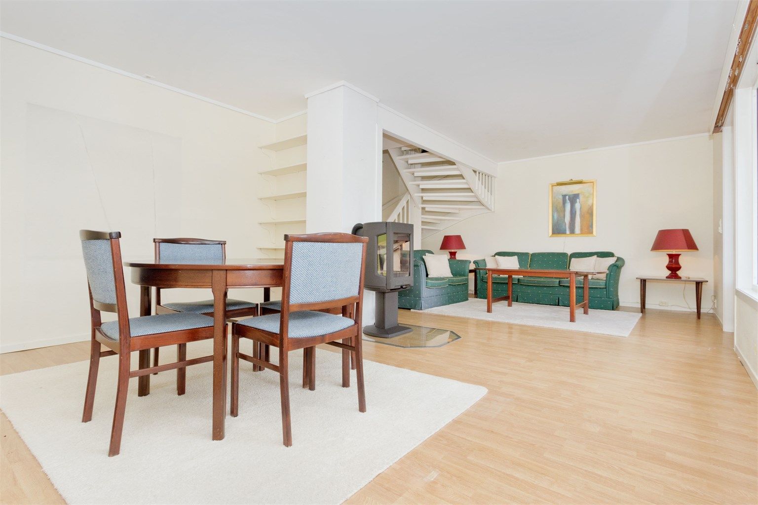 Åpen stue- og spisestue løsning med peisovn sentralt i rommet