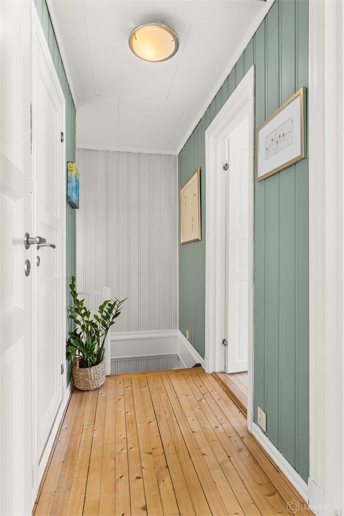 Gangen i andre etasje har tregulv og profilerte dører som leder inn til etasjens tre soverom og bad.