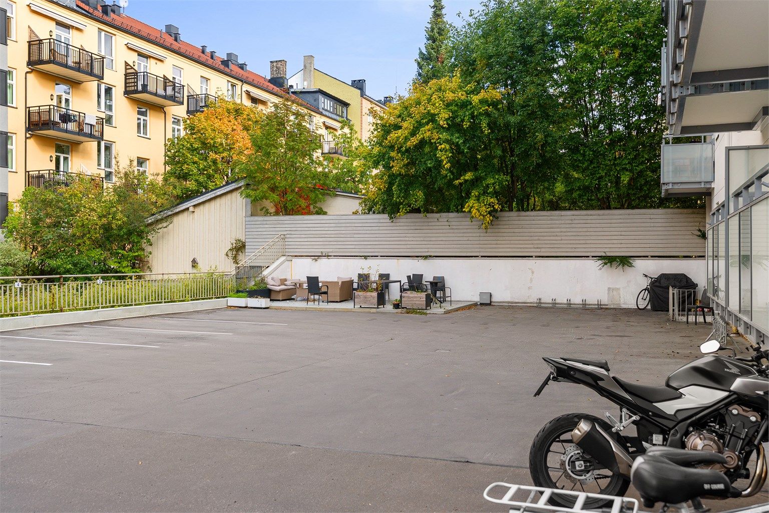 Sameiets felles gårdsplass med sittegruppe. Det er beboerparkering i området.