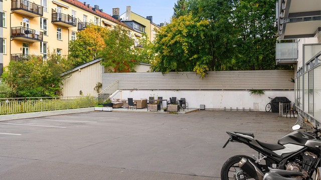 Sameiets felles gårdsplass med sittegruppe. Det er beboerparkering i området.