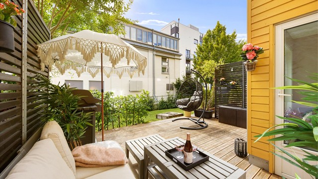 En grønn oase med plass til møbler, gassgrill og plantekasser