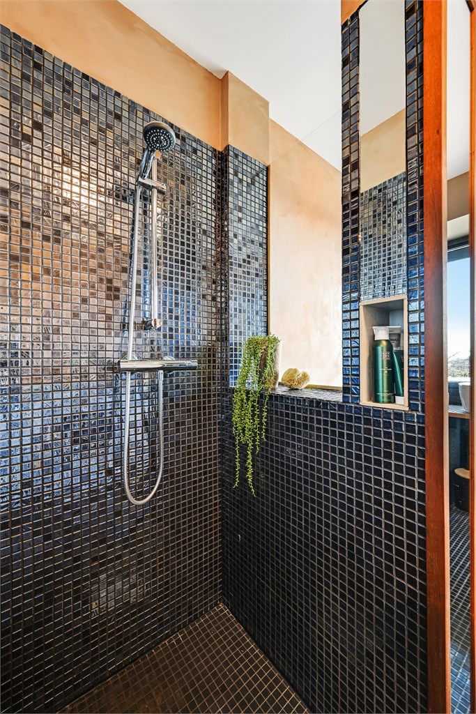 Dusjsonen har flislagte vegger og en praktisk nisje for oppbevaring.