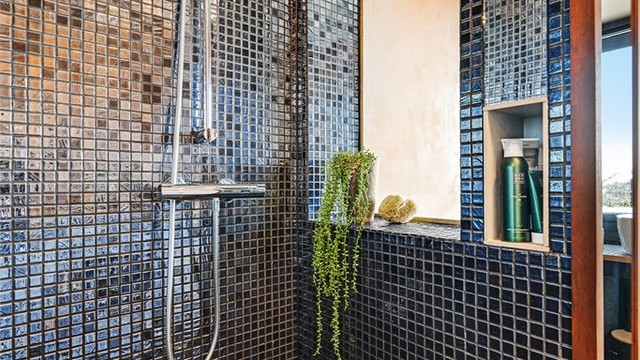 Dusjsonen har flislagte vegger og en praktisk nisje for oppbevaring.