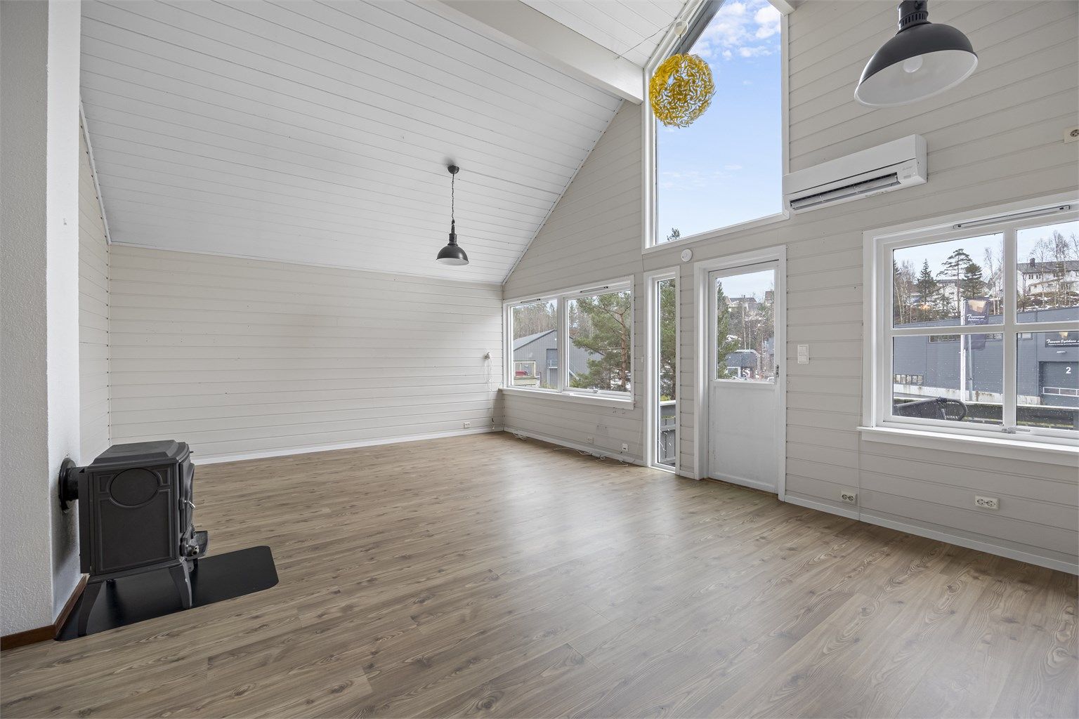 Her åpner stuen seg med en imponerende takhøyde og store vindusflater som gir en luftig romfølelse.