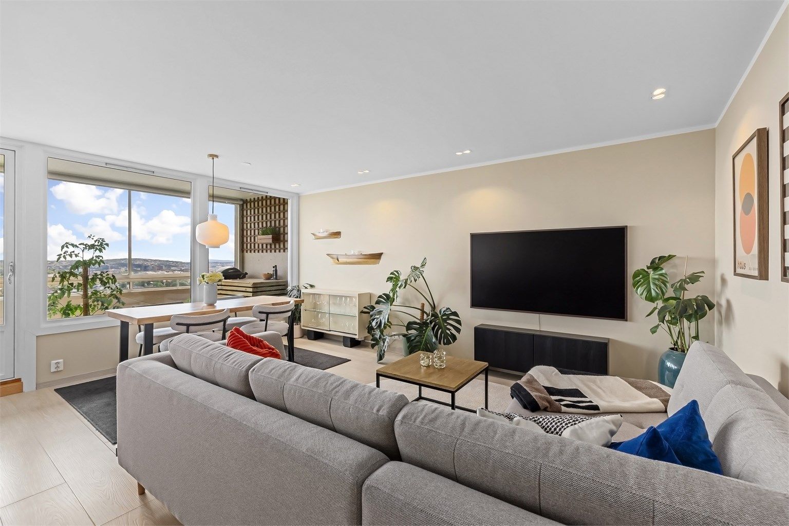 Lekker, romslig stue med store vindusflater som bidrar til mye naturlig lys inn i stuen, som sammen med de lyse overflatene skaper et naturlig lyst rom