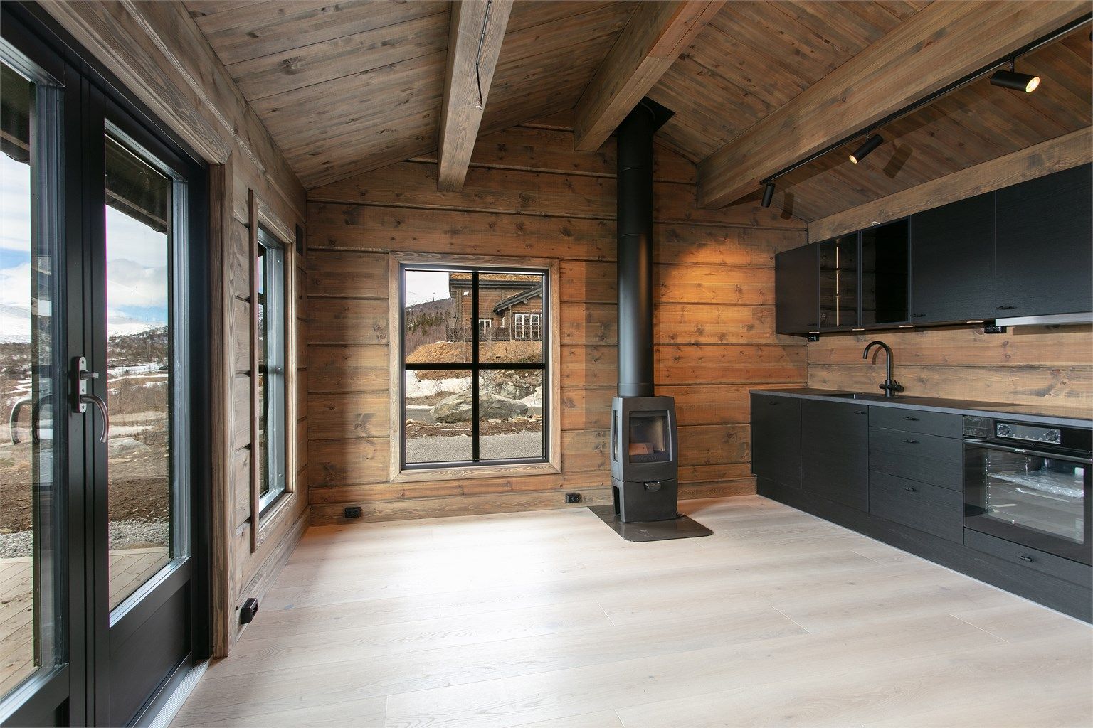 Fra kjøkkenet er det direkte utgang til markterrassen og uteområdet, som binder inne- og uterommet sammen.