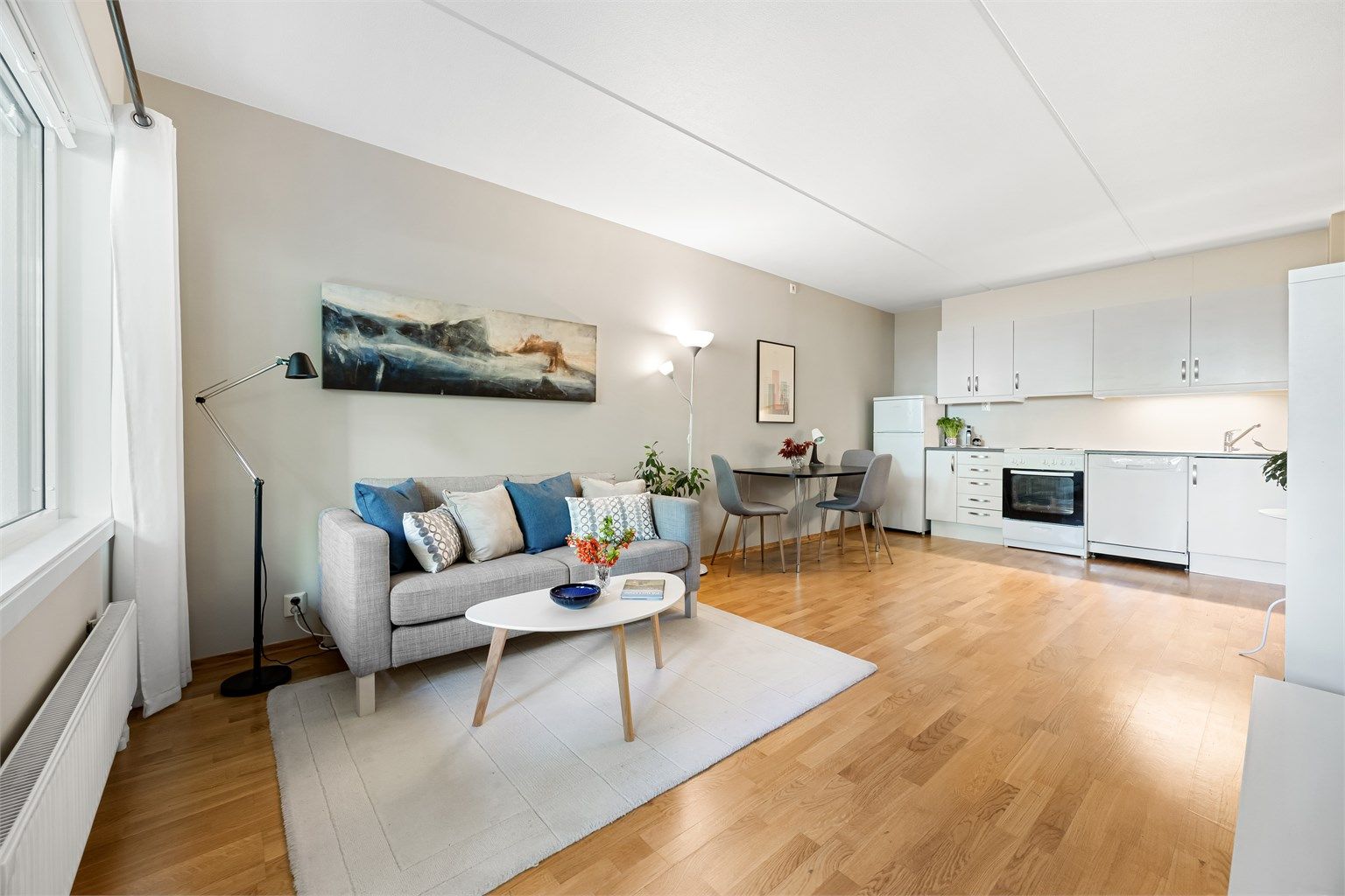 Åpen kjøkkenløsning mot stuen med god plass til både spisebord og sofagruppe.