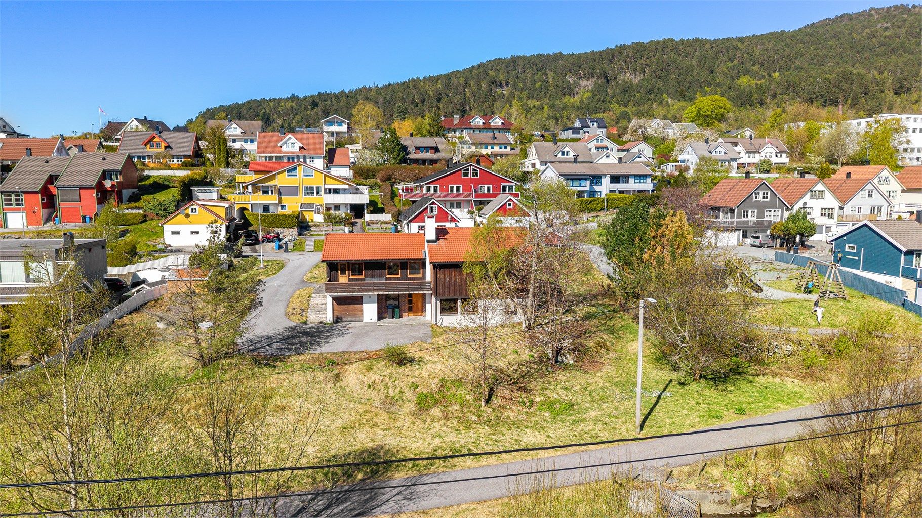 Dronebilde over bolig og den romslige hagen sett fra syd