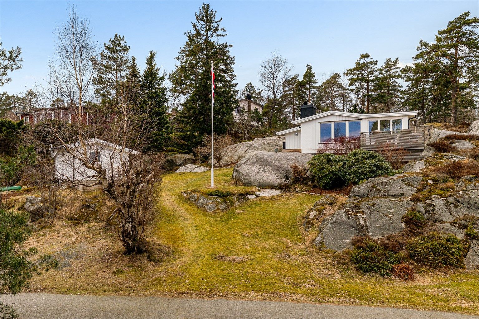 Hytta er fundamentert på fjell og ligger fint integrert i den kuperte naturtomten.