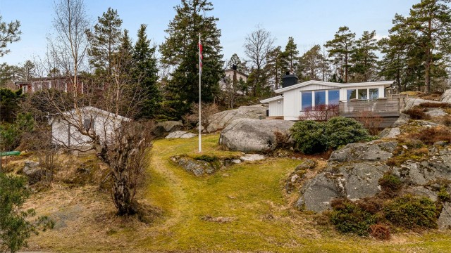 Hytta er fundamentert på fjell og ligger fint integrert i den kuperte naturtomten.