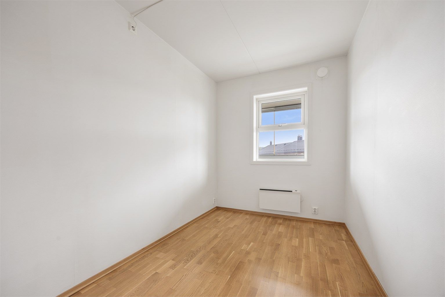Soverom med parkett på gulvet og plass til seng eller kontorpult.